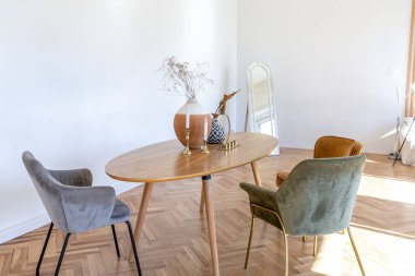 Ahşap elementleri ve beyaz duvarları olan geniş bir oturma odasının pahalı, hafif, lüks iç tasarımı. Orijinal ve alışılmadık dekoratif şeylerle dolu.