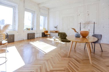 Ahşap elementleri ve beyaz duvarları olan geniş bir oturma odasının pahalı, hafif, lüks iç tasarımı. Orijinal ve alışılmadık dekoratif şeylerle dolu.