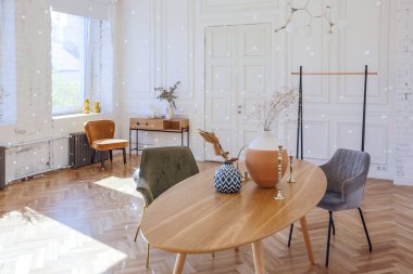 Ahşap elementleri ve beyaz duvarları olan geniş bir oturma odasının pahalı, hafif, lüks iç tasarımı. Orijinal ve alışılmadık dekoratif şeylerle dolu.