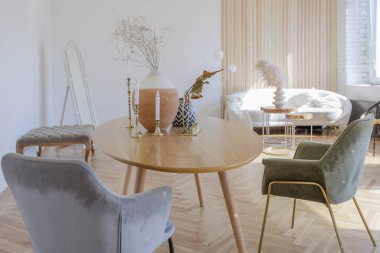 Ahşap elementleri ve beyaz duvarları olan geniş bir oturma odasının pahalı, hafif, lüks iç tasarımı. Orijinal ve alışılmadık dekoratif şeylerle dolu.