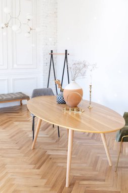 Ahşap elementleri ve beyaz duvarları olan geniş bir oturma odasının pahalı, hafif, lüks iç tasarımı. Orijinal ve alışılmadık dekoratif şeylerle dolu.