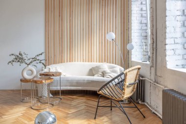 Ahşap elementleri ve beyaz duvarları olan geniş bir oturma odasının pahalı, hafif, lüks iç tasarımı. Orijinal ve alışılmadık dekoratif şeylerle dolu.