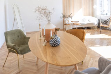 Ahşap elementleri ve beyaz duvarları olan geniş bir oturma odasının pahalı, hafif, lüks iç tasarımı. Orijinal ve alışılmadık dekoratif şeylerle dolu.