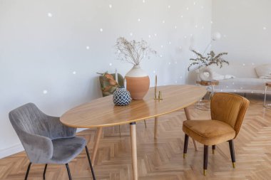 Ahşap elementleri ve beyaz duvarları olan geniş bir oturma odasının pahalı, hafif, lüks iç tasarımı. Orijinal ve alışılmadık dekoratif şeylerle dolu.