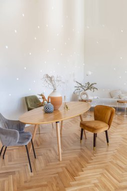 Ahşap elementleri ve beyaz duvarları olan geniş bir oturma odasının pahalı, hafif, lüks iç tasarımı. Orijinal ve alışılmadık dekoratif şeylerle dolu.