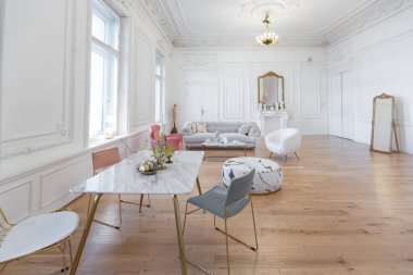 Büyük oturma odasının çok hafif barok tarzı bir iç mekanı. Beyaz duvarlar harika bir sıva ile süslenmiş. Altın elementli şık mobilyalı kraliyet tarzı bir daire.