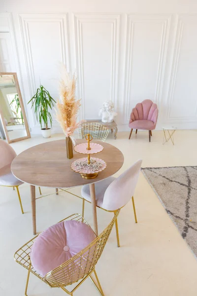 パステルピンク色のモダンなスタイリッシュな家具と日光の下でスタッコ型の白い壁とリビングルームの繊細で居心地の良い光のインテリア — ストック写真
