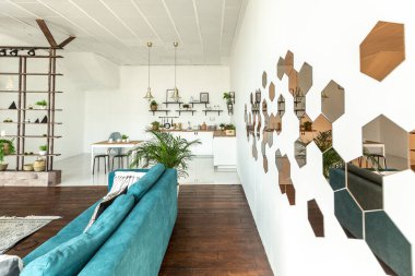 Ahşap ve beyazla dekore edilmiş geniş bir stüdyo daire. Minimalist tasarım ve güneş ışığı altında kocaman pencereler. Mutfak ve yaşam alanı