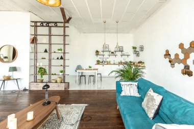 Ahşap ve beyazla dekore edilmiş geniş bir stüdyo daire. Minimalist tasarım ve güneş ışığı altında kocaman pencereler. Mutfak ve yaşam alanı