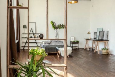 Ahşap ve beyazla dekore edilmiş geniş bir stüdyo daire. Minimalist tasarım ve güneş ışığı altında kocaman pencereler. Mutfak ve yaşam alanı