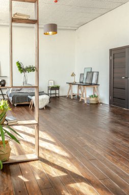 Ahşap ve beyazla dekore edilmiş geniş bir stüdyo daire. Minimalist tasarım ve güneş ışığı altında kocaman pencereler. Mutfak ve yaşam alanı