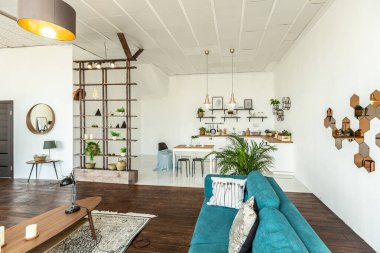 Ahşap ve beyazla dekore edilmiş geniş bir stüdyo daire. Minimalist tasarım ve güneş ışığı altında kocaman pencereler. Mutfak ve yaşam alanı