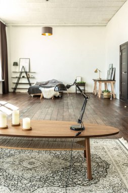 Ahşap ve beyazla dekore edilmiş geniş bir stüdyo daire. Minimalist tasarım ve güneş ışığı altında kocaman pencereler. Mutfak ve yaşam alanı