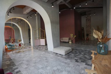 Doğuda büyük bir apartman dairesi. Çatı katı tarzı, kemer, aydınlatma ve parlak turuncu elementlerle harmanlanmış.