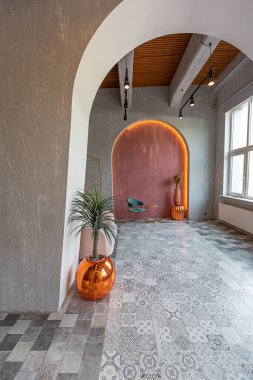 Doğuda büyük bir apartman dairesi. Çatı katı tarzı, kemer, aydınlatma ve parlak turuncu elementlerle harmanlanmış.