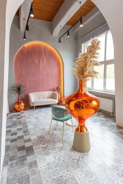 Doğuda büyük bir apartman dairesi. Çatı katı tarzı, kemer, aydınlatma ve parlak turuncu elementlerle harmanlanmış.