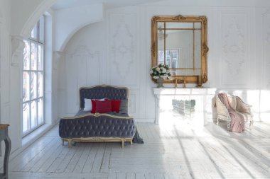 Geniş, parlak bir oturma odası. Modern tasarımı, antika dekorları ve eski tarz şık mobilyaları ve yerden tavana kadar birçok penceresi var.