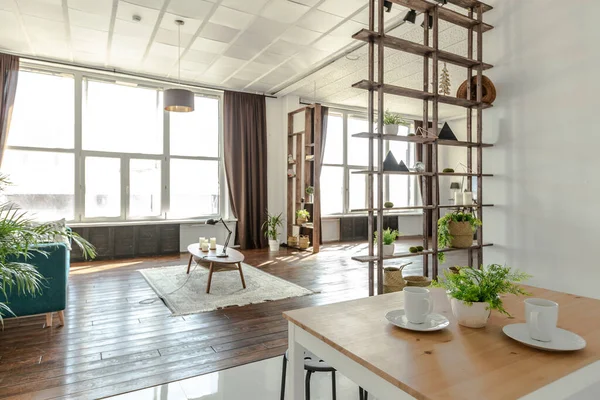 宽敞的演播室公寓 用木料和白色装饰 最小的设计 有巨大的窗户在阳光下 厨房区和生活区 — 图库照片
