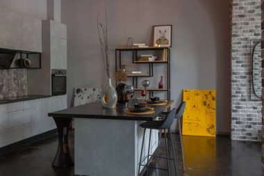 Ortaçağ şatosu tarzında parlak aksanlı, vahşi bir apartman dairesinin modern lüks tasarımı. Yemek pişirmek ya da zaman geçirmek için bir adası olan şık gri bir mutfak.