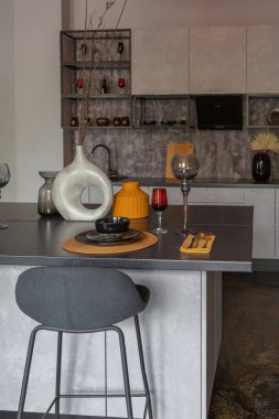 Ortaçağ şatosu tarzında parlak aksanlı, vahşi bir apartman dairesinin modern lüks tasarımı. Yemek pişirmek ya da zaman geçirmek için bir adası olan şık gri bir mutfak.