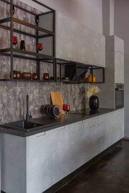 Ortaçağ şatosu tarzında parlak aksanlı, vahşi bir apartman dairesinin modern lüks tasarımı. Yemek pişirmek ya da zaman geçirmek için bir adası olan şık gri bir mutfak.