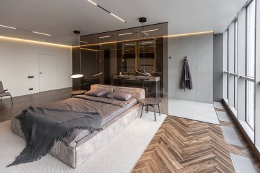 Modern LED ışıklandırmalı ve şık mobilyalı prestijli lüks otelin pahalı iç tasarımı. Lavabosu olan alan yatak odasından koyu camla ayrılmış.