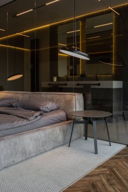 Modern LED ışıklandırmalı ve şık mobilyalı prestijli lüks otelin pahalı iç tasarımı. Lavabosu olan alan yatak odasından koyu camla ayrılmış.