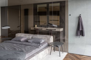 Modern LED ışıklandırmalı ve şık mobilyalı prestijli lüks otelin pahalı iç tasarımı. Lavabosu olan alan yatak odasından koyu camla ayrılmış.