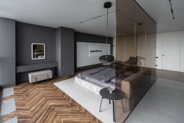 Modern LED ışıklandırmalı ve şık mobilyalı prestijli lüks otelin pahalı iç tasarımı. Lavabosu olan alan yatak odasından koyu camla ayrılmış.