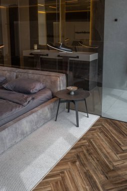 Modern LED ışıklandırmalı ve şık mobilyalı prestijli lüks otelin pahalı iç tasarımı. Lavabosu olan alan yatak odasından koyu camla ayrılmış.