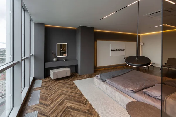 モダンなLed照明とスタイリッシュな家具と暗い色調で権威ある高級ホテルの部屋のクールな高価なインテリアデザイン シンク付きの領域は寝室から暗いガラスで区切られています — ストック写真