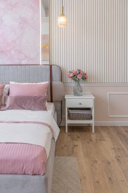 Yatak odasının yakın görüntüsü modern, yumuşak bir iç mekan sıcak, hassas pastel, pembe ve bej renkler.