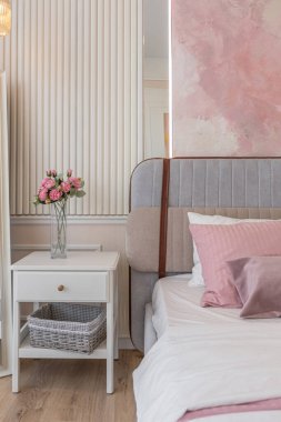 Yatak odasının yakın görüntüsü modern, yumuşak bir iç mekan sıcak, hassas pastel, pembe ve bej renkler.