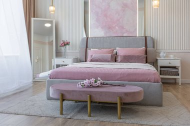 Yatak odasının yakın görüntüsü modern, yumuşak bir iç mekan sıcak, hassas pastel, pembe ve bej renkler.