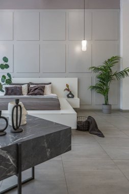 LED ışıklandırmalı dekoratif oyuklar ve gri ve beyaz renkli ve geometrik şekilli büyük bir panoramik pencere ile şık, modern yatak odası iç tasarımı