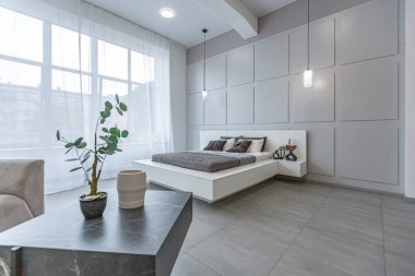 LED ışıklandırmalı dekoratif oyuklar ve gri ve beyaz renkli ve geometrik şekilli büyük bir panoramik pencere ile şık, modern yatak odası iç tasarımı