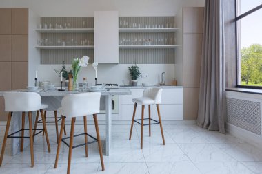 Yakın manzaralı mutfak, yemek masası ve minimalist hafif bar tabureleri yumuşak pastel bej renkli modern geniş bir stüdyo dairesinin lüks tasarımı.