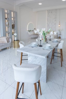 Mutfak alanı, yatak odası ve kanepenin arkasında kocaman aynası olan modern geniş bir stüdyo dairesinin minimalist hafif zarif tasarımı. Zeminde fayanslar ve yüksek tavan.