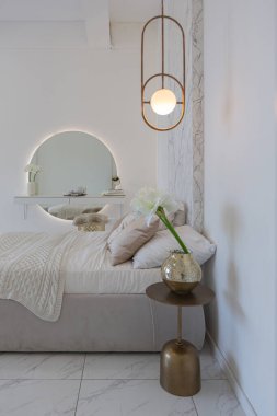 Kapalı yatak odası manzaralı, minimalist hafif, şık, lüks tasarlanmış yumuşak pastel bej renkli modern geniş bir stüdyo dairesi olan bir yer.