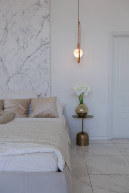 Kapalı yatak odası manzaralı, minimalist hafif, şık, lüks tasarlanmış yumuşak pastel bej renkli modern geniş bir stüdyo dairesi olan bir yer.