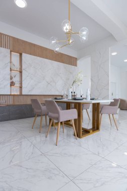 Minimalist tarzda, mermer süslemeli ve kocaman pencereli, modern bir apartman dairesi tasarımı. Mutfakta ve oturma odasında gün ışığı.