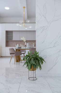 Minimalist tarzda, mermer süslemeli ve kocaman pencereli, modern bir apartman dairesi tasarımı. Mutfakta ve oturma odasında gün ışığı.