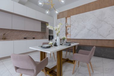 Şık bir mutfak ve açık renkli bir yemek masası. Minimalist tarzda, mermer süslemeli ve kocaman pencereli modern bir apartman dairesi tasarımı. İçeride gün ışığı.