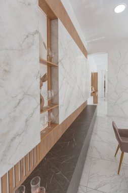 Minimalist tarzda, mermer süslemeli ve kocaman pencereli, modern bir apartman dairesi tasarımı. Mutfakta ve oturma odasında gün ışığı.