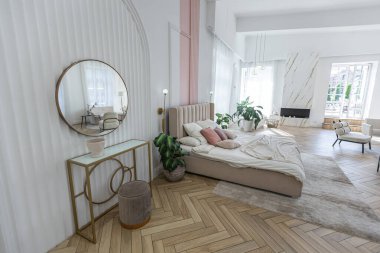 Güneşli bir günde şık modern parlak tasarımı, giyinme odası, yatak odası, oturma odası ve banyosu olan geniş, açık planlı bir daire.