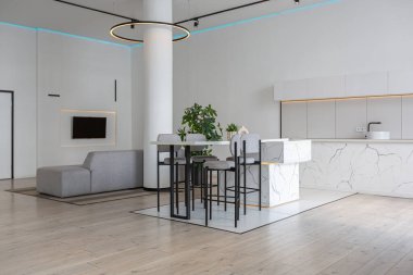 Güneşli bir günde mermer süslemeli pahalı bir evin minimalist modern lüks tasarımı. Alçılı beyaz duvarlar, parke, dekoratif ışıklandırma ve içeride kimse yok.
