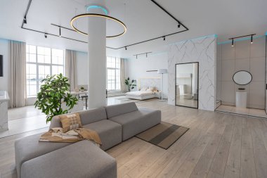 Güneşli bir günde mermer süslemeli pahalı bir evin minimalist modern lüks tasarımı. Alçılı beyaz duvarlar, parke, dekoratif ışıklandırma ve içeride kimse yok.