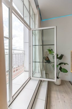 Güneşli bir günde mermer süslemeli pahalı bir evin minimalist modern lüks tasarımı. Alçılı beyaz duvarlar, parke, dekoratif ışıklandırma ve içeride kimse yok.