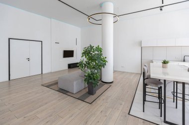 Güneşli bir günde mermer süslemeli pahalı bir evin minimalist modern lüks tasarımı. Alçılı beyaz duvarlar, parke, dekoratif ışıklandırma ve içeride kimse yok.