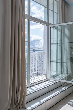 Güneşli bir günde mermer süslemeli pahalı bir evin minimalist modern lüks tasarımı. Alçılı beyaz duvarlar, parke, dekoratif ışıklandırma ve içeride kimse yok.